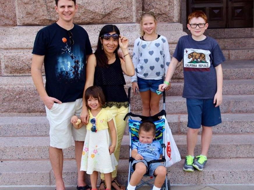 William Mock standing with his family on stone steps